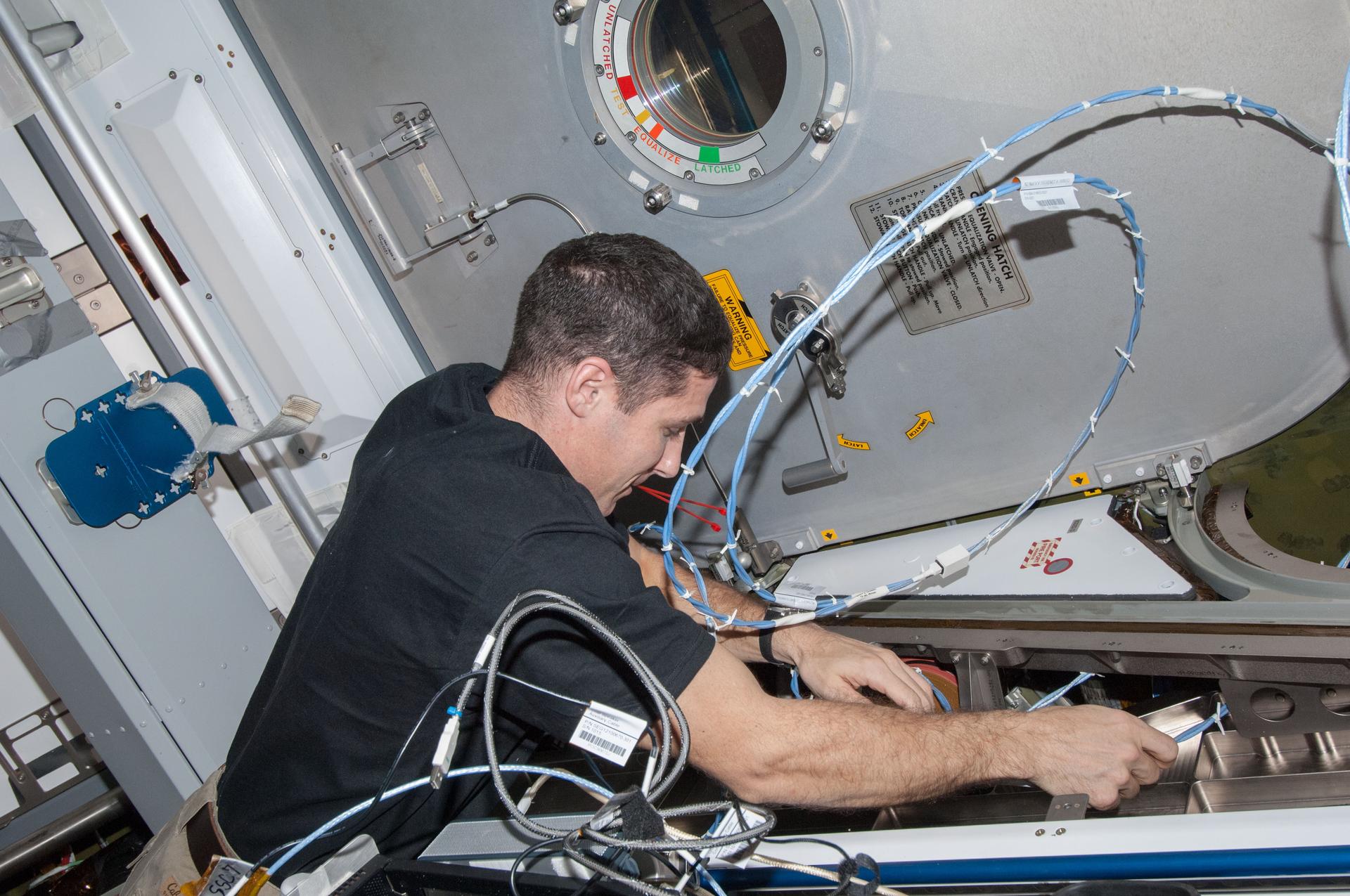 Michael Hopkins installing wire harnesses in the Harmony node