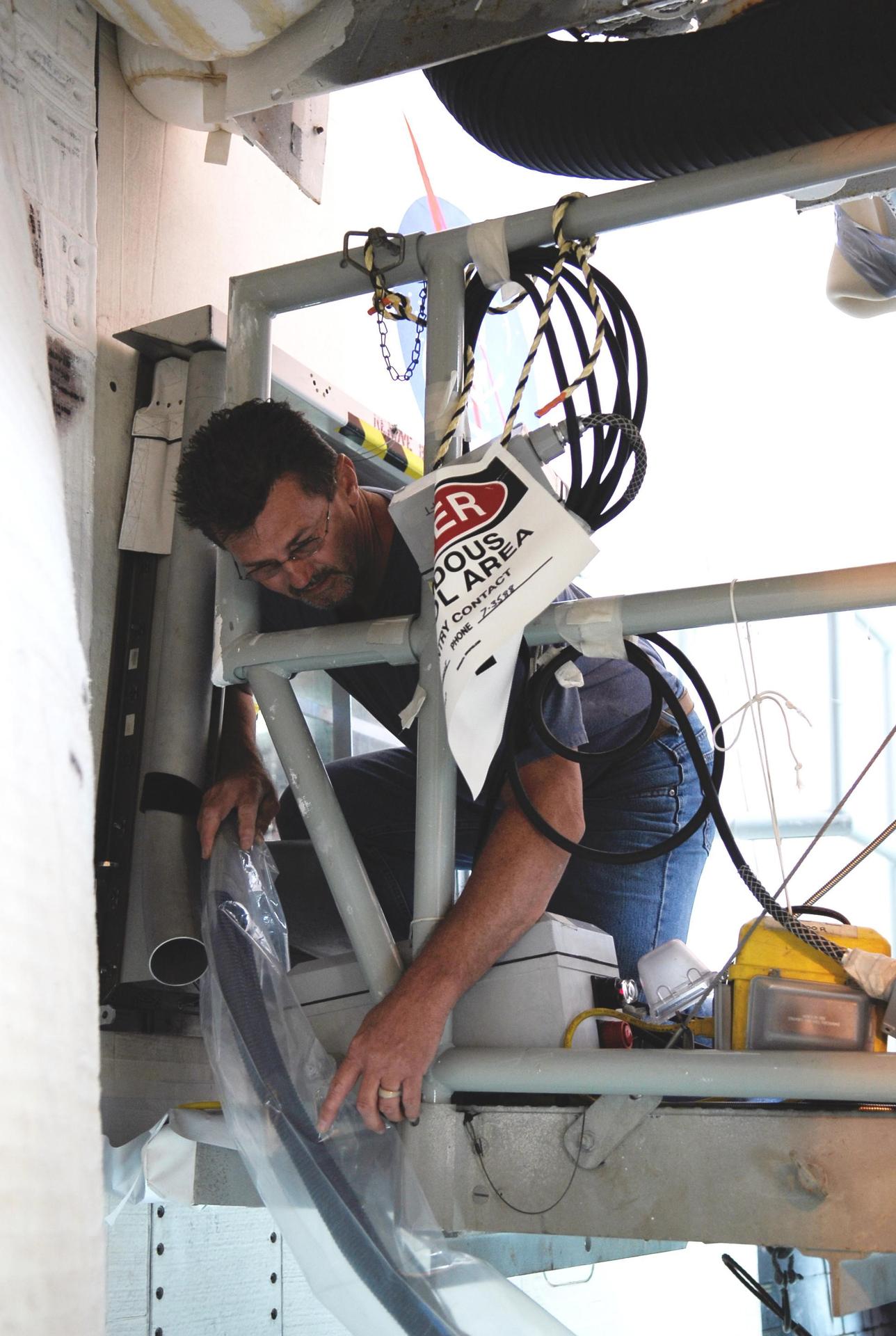 Technician preparing an electrical harness test cable at Kennedy